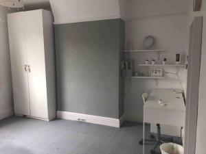 Cette chambre dispose d'un mur gris, d'un bureau et d'étagères. dans l'établissement Luxury 4 bedroom house in London featured on TV, à Londres