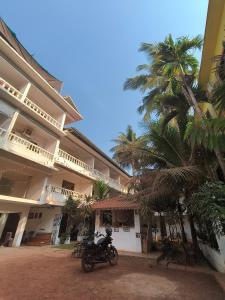 a motorcycle parked in front of a building with palm trees at SHANKAR by the SEA, 2 min from Mandrem Beach in Mandrem