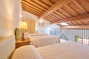 um quarto com três camas e uma mesa com um candeeiro em Poggio all'Agnello Sport & Active Holidays em Populonia