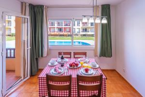 a dining room table with a red and white checkered table cloth at Aptos. Comte D´Empuries in Empuriabrava