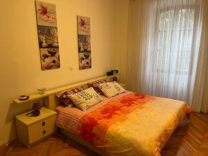 sypialnia z łóżkiem z kolorowym kocem w obiekcie Noemi City Apartments w Puli