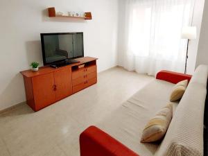 a living room with a television and a couch at Descanso en el Paraíso: Oropesa del Mar in Oropesa del Mar