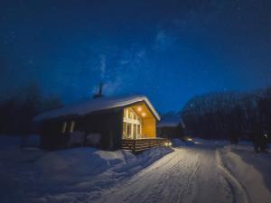 ein Haus mit schneebedecktem Dach im Schnee in der Unterkunft Chill Village in Biei