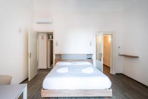 una camera da letto con un grande letto bianco con due cuscini di PugliaMare Room and Apartment by Wonderful Italy a Bisceglie