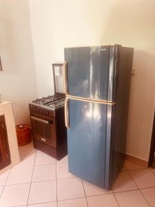 a kitchen with a stainless steel refrigerator and a stove at 3 bedroom white house malindi in Malindi