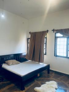 a bedroom with a bed in a room with two windows at 3 bedroom white house malindi in Malindi