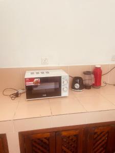 a microwave sitting on top of a kitchen counter at 3 bedroom white house malindi in Malindi