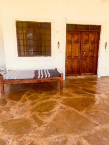 a room with a bed and two wooden doors at 3 bedroom white house malindi in Malindi