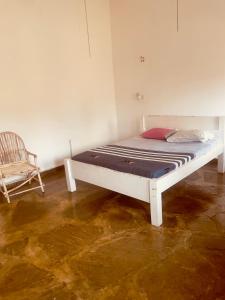 a white bed in a room with a chair at 3 bedroom white house malindi in Malindi