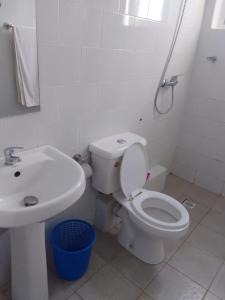 a white bathroom with a toilet and a sink at 3 bedroom white house malindi in Malindi