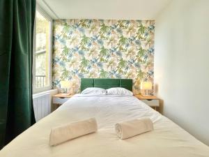 1 dormitorio con 1 cama grande y papel pintado tropical en Le TerraVerde - SOnights, en Château-du-Loir