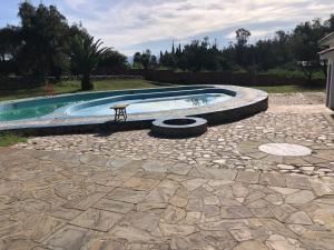 a pool with a table and a bench in a yard at Poneloya in Tarija