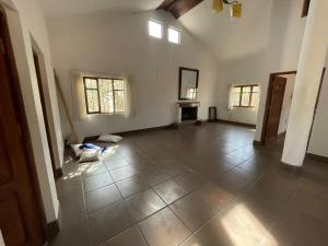 an empty room with a large tile floor and windows at Poneloya in Tarija