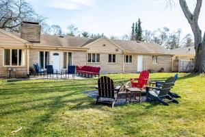 a house with chairs and a table in the yard at Perfect Sprawling Ranch for Group Game Day Stay! King Beds, Firepit, & Pet Friendly with Huge Fenced Yard in South Bend +36 photos