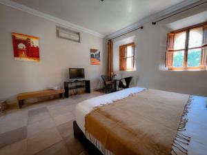 a bedroom with a large bed and a television at Maidan El Arsa in Oulad Mazoug