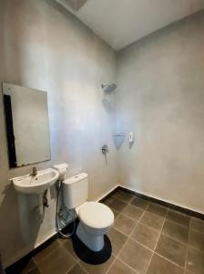 a bathroom with a toilet and a sink at Escotel Krisnantara in Canggu