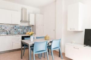 uma cozinha com uma mesa e cadeiras azuis em Corte dei Fiori Acquaviva Apartments em Marittima