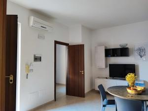 um quarto com uma mesa e uma cozinha com uma sala de jantar em Corte dei Fiori Acquaviva Apartments em Marittima