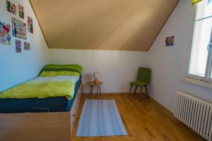 Naturoase Säntisbligg am Bach und Wald في Kradolf: غرفة نوم صغيرة بها سرير وكرسي
