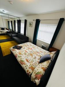 利物浦的住宿－Liberty Inn Room with sharing toilet and kitchen，一间卧室配有一张床、一张沙发和一面镜子