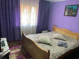 Brăduleţ的住宿－Casa SEBASTIAN，一间卧室配有一张紫色墙壁的床
