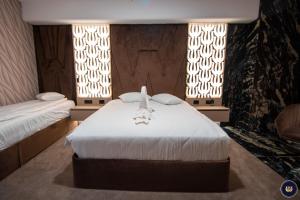 a bedroom with two beds and two windows at Wonderland Cluj Resort in Cluj-Napoca