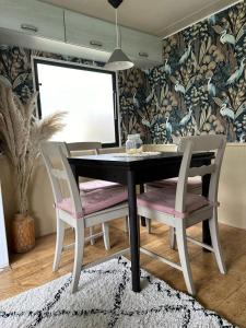 una sala da pranzo con un tavolo nero e due sedie di Stacaravan aan het “Drents Friese Wold”. a Elsloo