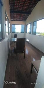 um quarto com uma mesa, uma cadeira e janelas em não disponível! em Itamaracá