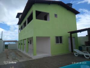 uma casa verde com uma piscina em frente em não disponível! em Itamaracá