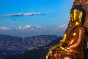 a gold statue looking out at the mountains at Dadaghare Homestay & View Point Restaurant in Panauti