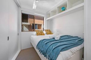 a bedroom with a bed with a blue blanket on it at Waterfront Bliss in Margate - 30 min from Brisbane in Redcliffe