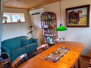 a living room with a blue couch and a wooden table at Brösarp Källagården Vedboden in Brösarp