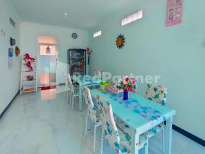une salle à manger avec une table bleue et des chaises dans l'établissement Joy Homestay Near UMJ Jember Mitra RedDoorz, à Jember