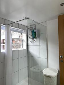 La salle de bains est pourvue d'une douche avec une porte en verre. dans l'établissement COZY PLACE LIVERPOOL, à Liverpool