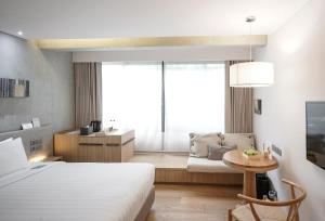 a hotel room with a bed and a couch at Ad Lib Hotel Bangkok in Bangkok