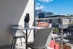 Xenia Aparthotel by Totalstay في كيب تاون: طاولة وكراسي على شرفة مطلة على مدينة