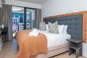 a bedroom with a large bed with a large window at Xenia Aparthotel by Totalstay in Cape Town