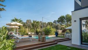 Un patio trasero con piscina y terraza de madera. en ONDA 8, Emma Villas, en Santa Maria di Scacciano