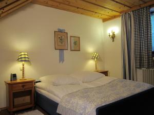 una camera con un letto, due lampade e una finestra di Ferienwohnungen Elisabeth am See a Rottach-Egern