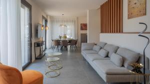 una sala de estar con un sofá y una mesa en MAREA 8, Emma Villas, en Santa Maria di Scacciano