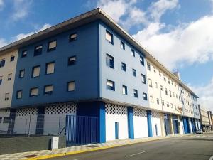 niebiesko-biały budynek po stronie ulicy w obiekcie LuxSevilla Moderno 1 Room Piscina Parking w mieście Bormujos