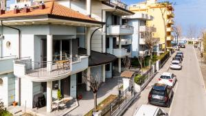 apartamentowiec z samochodami zaparkowanymi na ulicy w obiekcie Appartamenti Desi Riccione w mieście Riccione