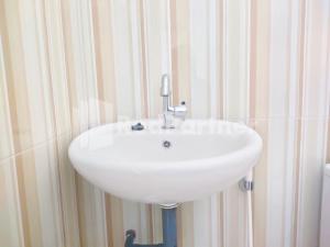 a white sink in the corner of a bathroom at Joy Homestay Near UMJ Jember Mitra RedDoorz in Jember