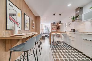 a kitchen with a bar with stools in it at Victoria 16 Premium by Nagoa Homes in Málaga