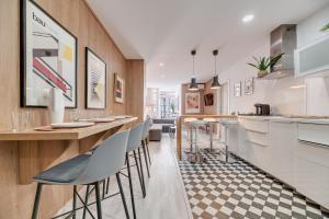 uma cozinha com um bar com bancos em Victoria 16 Premium by Nagoa Homes em Málaga