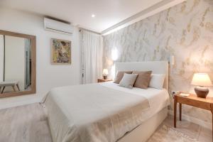 a white bedroom with a large bed and a window at Victoria 16 Premium in Málaga