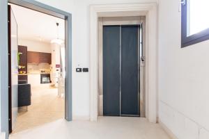einen Flur mit einer blauen Tür, die zu einer Küche führt in der Unterkunft Appartamenti Desi Riccione in Riccione
