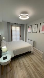 a bedroom with a large white bed and a table at Casa Alberto 2 izda in Tudela