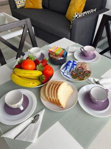 una mesa con platos de comida y fruta. en LuxSevilla Moderno 1 Room Piscina Parking, en Bormujos