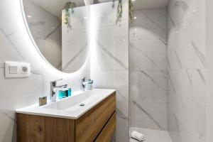 La salle de bains est pourvue d'un lavabo et d'un miroir. dans l'établissement Albane - modern 2 slaapkamer appartement, à Ostende